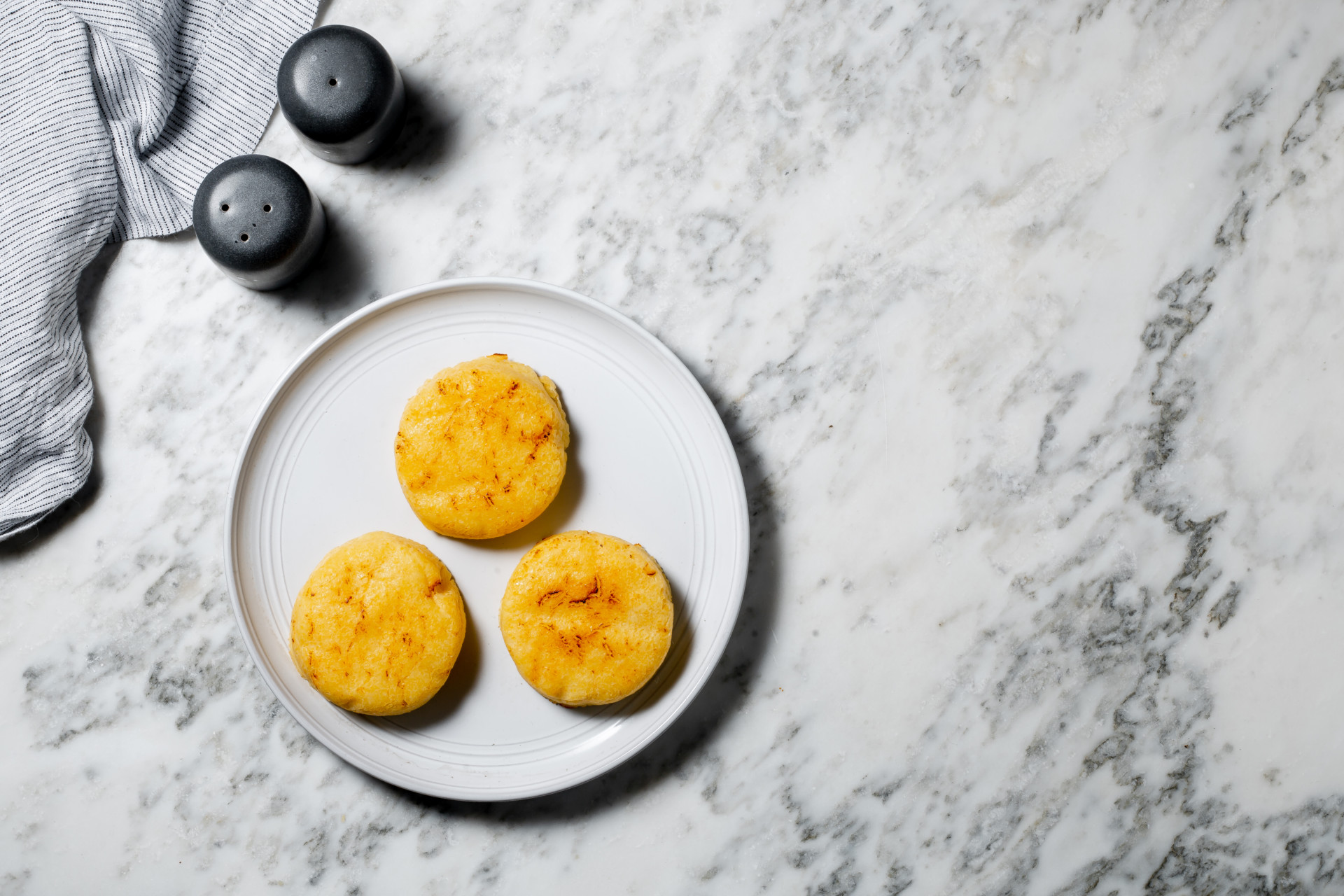 Polenta Cake With Garlic Confit on plate