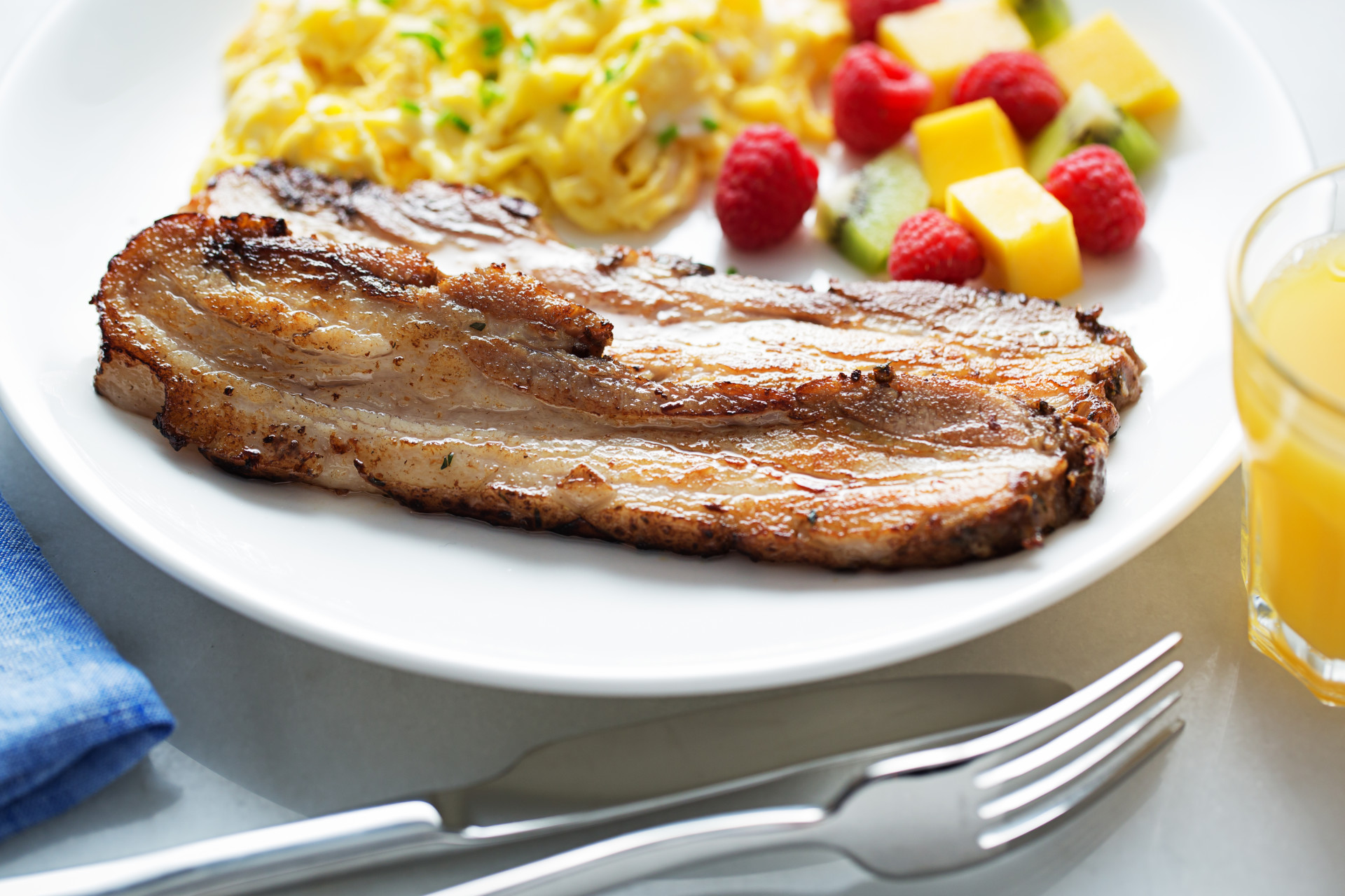 Plated Pork belly slices with eggs and fruit