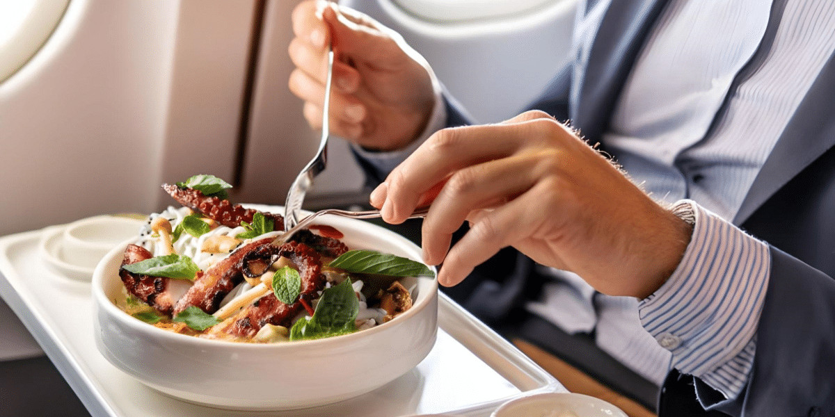 Man on plane being served a bowl with sous vide octopus