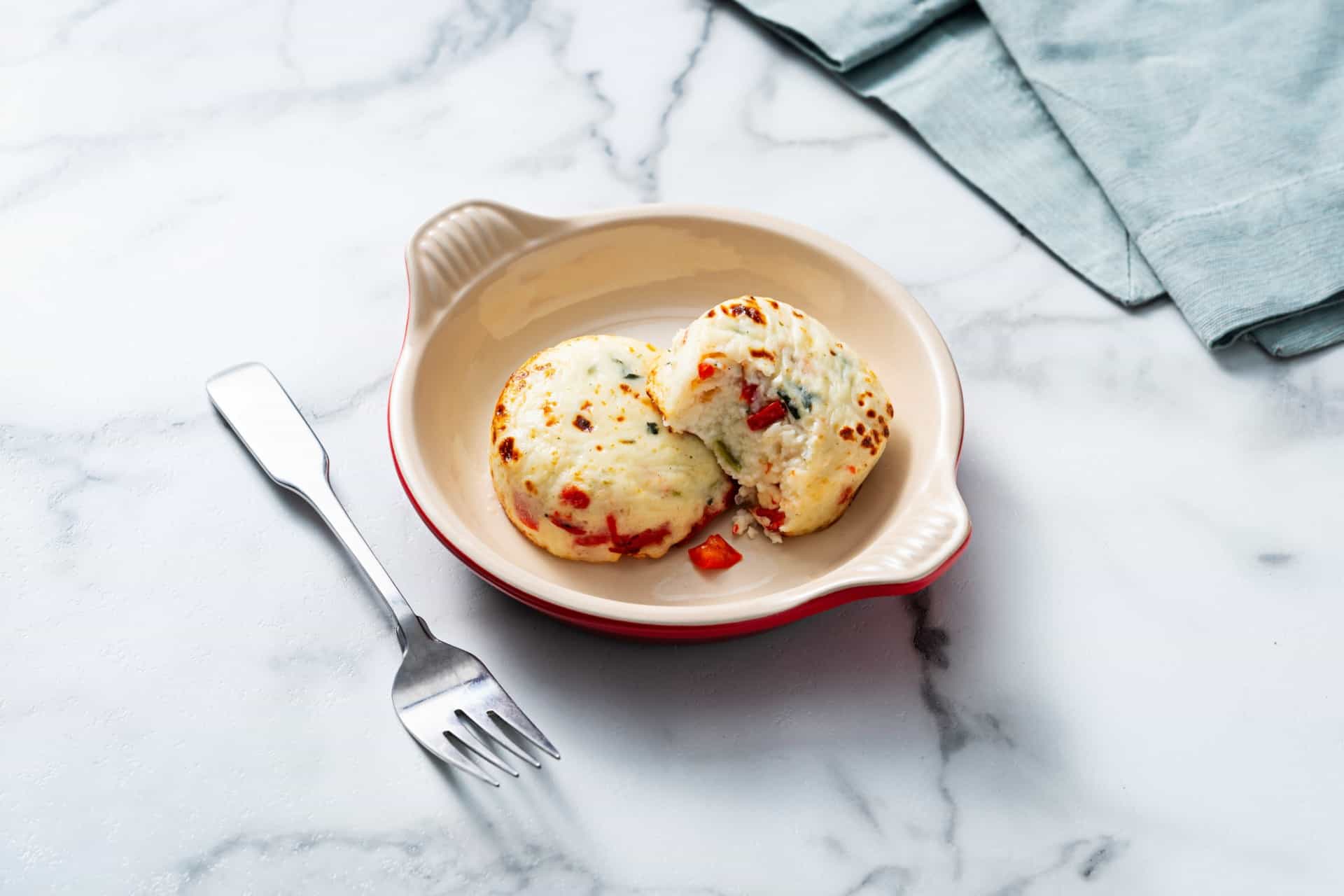egg white with cheese and peppers in a red dish